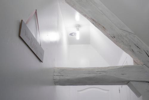 une chambre blanche avec un panneau sur le mur dans l'établissement Gîte 