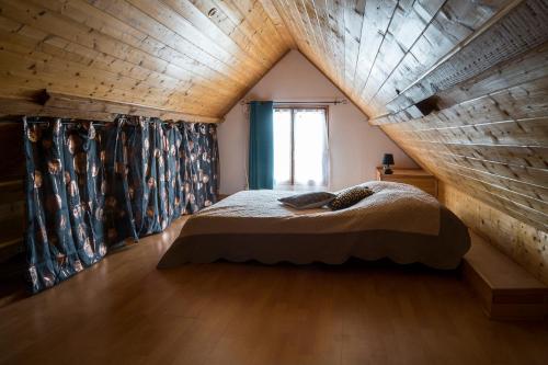 un lit dans une chambre avec un plafond en bois dans l'établissement Gîte 