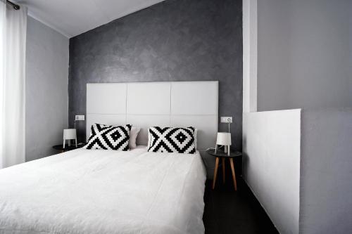 a bedroom with a large white bed with two pillows at Piso Centro de Castellón in Castellón de la Plana