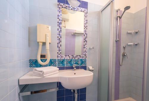 a bathroom with a sink and a shower with a mirror at Vivaldi Appartamenti in Marinella di Selinunte