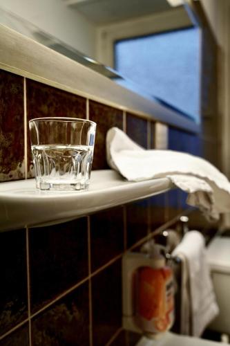 a glass sitting on a shelf in a bathroom at Hotel Berliner Hof in Düsseldorf