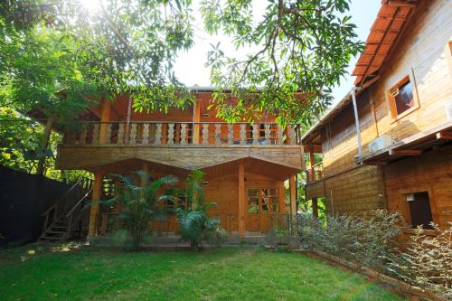 a house with a deck on the side of it at Brushwood Villa- Cottages and Bar in Palolem