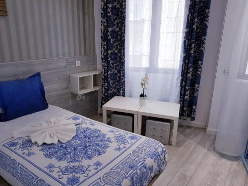 a bedroom with a bed and a table and a window at Hostal Main Street Madrid in Madrid