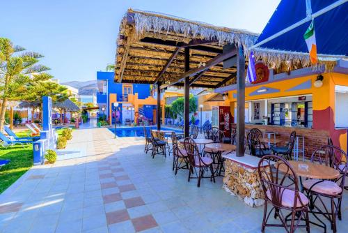 a restaurant with tables and chairs on a patio at Eltina Apartments in Malia