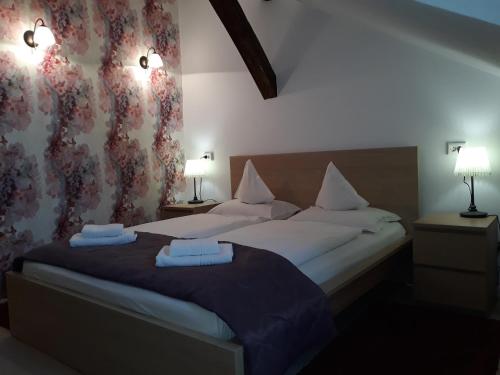 a bedroom with two beds with white sheets and a purple blanket at Pensiunea Casa Rusu in Baia Mare