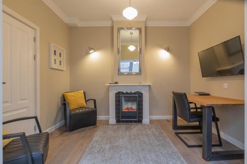 a living room with a fireplace and a table at ExLibris Boutique Hotel in Leiden