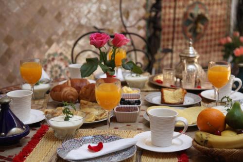 een tafel gevuld met eten en sinaasappelsap en drankjes bij Riad Chalymar in Marrakesh