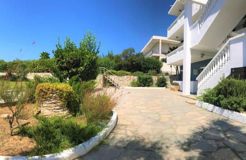 a patio outside of a white building with plants at Poseidon Seaview Studios in Afitos