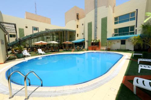 a large swimming pool in front of a building at Eastyard Dammam Hotel - Formerly Ramada by Wyndham Dammam in Dammam