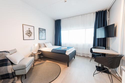 a hotel room with a bed and a couch and a table at Forenom Aparthotel Helsinki Pikku Huopalahti in Helsinki