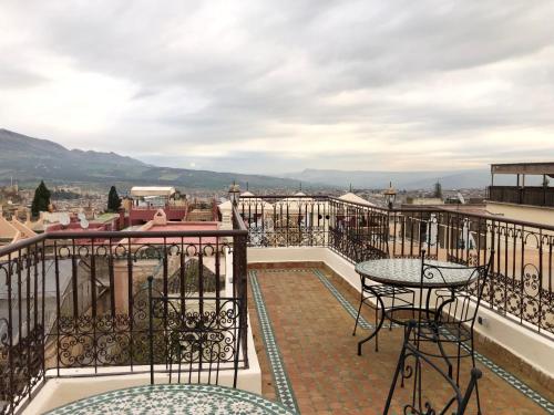 a balcony with a table and a view of the city at Le Grand Alcazar - Riad in Fès