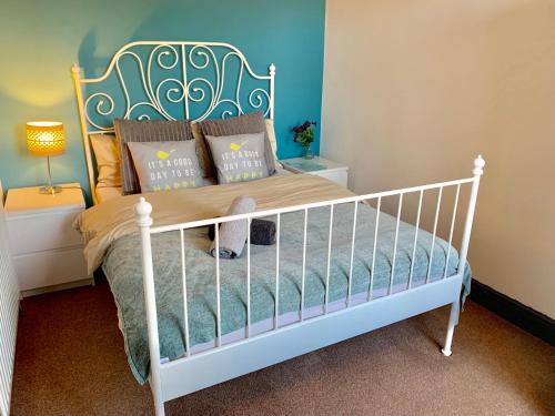 1 dormitorio con cuna blanca con almohadas en Durban House Kettering, en Kettering