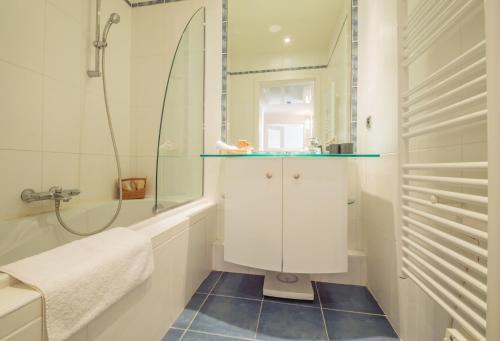 une salle de bain avec une douche, un lavabo et un miroir dans l'établissement Sunlight Properties - 