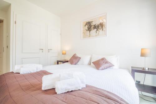 a bedroom with a large white bed with towels on it at Sunlight Properties - "Kahlua" - Cannes - Sea front in Cannes