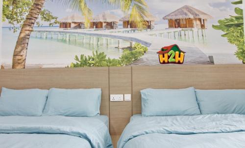 two beds in a bedroom with a view of a beach at H2H - Summer Holidays Majestic Ipoh in Ipoh