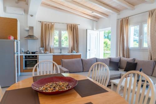 een keuken en een woonkamer met een tafel en een bank bij Apartment Sofia - Beachfront in Agios Spyridon Corfu