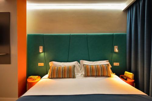 a bed with a green headboard and two pillows at Hotel Apartamento Bajamar in Las Palmas de Gran Canaria
