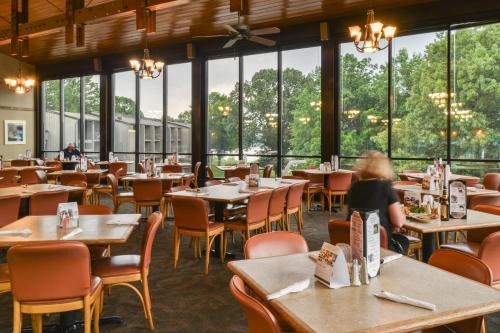 a dining room with tables and chairs and windows at Barren River Lake State Resort Park in Lucas