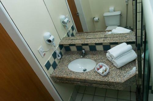 a bathroom with a sink and a toilet at Calhau Praia Hotel in São Luís