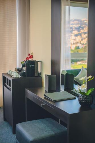 a desk with a laptop computer on top of it at Louis V Hotel Beirut in Beirut