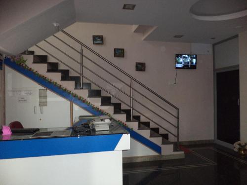 een trap in een gebouw met een tv aan de muur bij Blue Moon Residency in Mysore