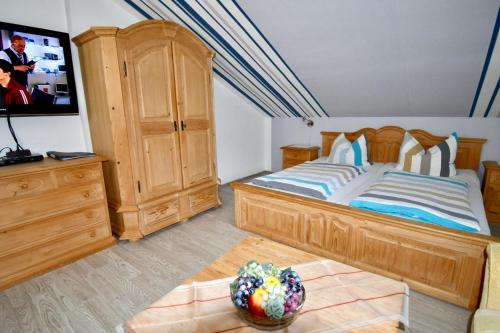 a bedroom with a large bed and a wooden cabinet at Gästehaus Steuer in Bruttig-Fankel
