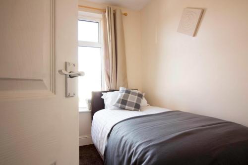 a small bedroom with a bed with a window at Brook House in Selby