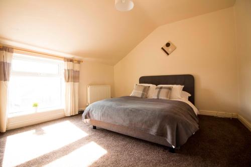 a bedroom with a bed and a large window at Brook House in Selby