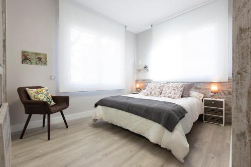 a bedroom with a bed and a chair and a window at Urban Sabadell in Sabadell