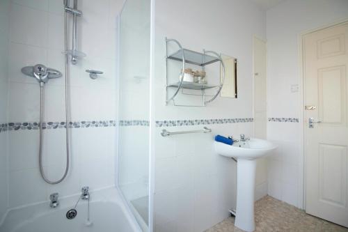 a white bathroom with a shower and a sink at Brook House in Selby