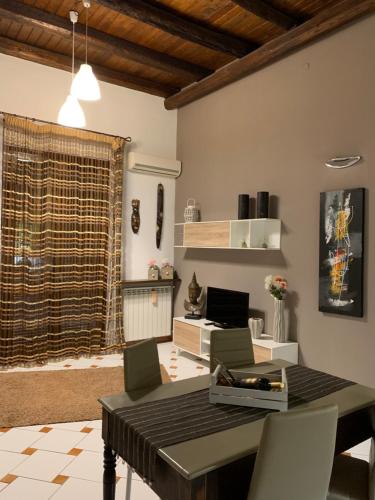 a dining room with a table and chairs in a room at Casa nel Vicolo in Palermo