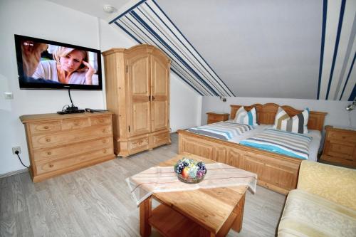 a bedroom with a bed and a tv on the wall at Gästehaus Steuer in Bruttig-Fankel