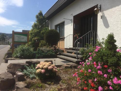 a house with flowers in the front yard at Gästehaus Steuer in Bruttig-Fankel