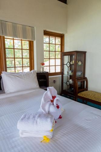 a towel animal sitting on top of a bed at Cranganor History Café & Riverside Château in Parūr