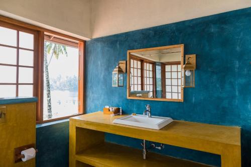a bathroom with a sink and a mirror at Cranganor History Café & Riverside Château in Parūr