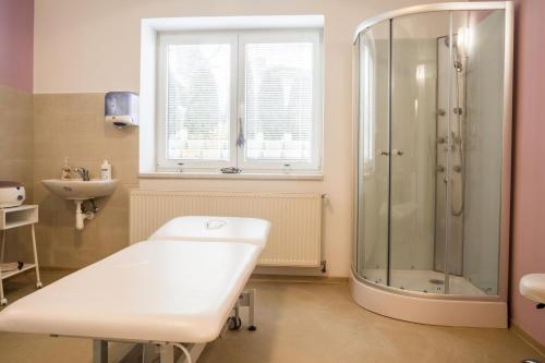 a white bathroom with a shower and a sink at Villa A. Malka in Poděbrady
