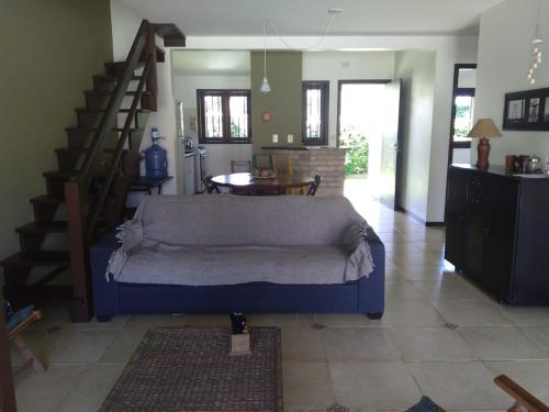 a living room with a couch and a staircase at Casa Caribe in Garopaba