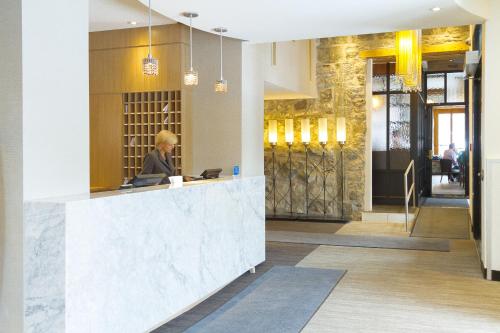 a woman sitting at a counter in a lobby at Hotel Port-Royal in Quebec City