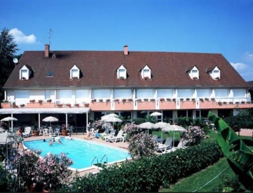 un grand hôtel avec une piscine en face dans l'établissement Les Songes de Buxy, à Buxy