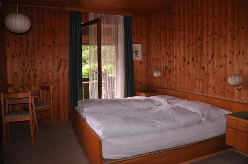 a bedroom with a bed and a window and a chair at Gasthof Schluff in Soprabolzano