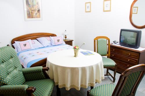 - une chambre avec un lit, une table et des chaises dans l'établissement Samson Apartment, à Hajdúszoboszló