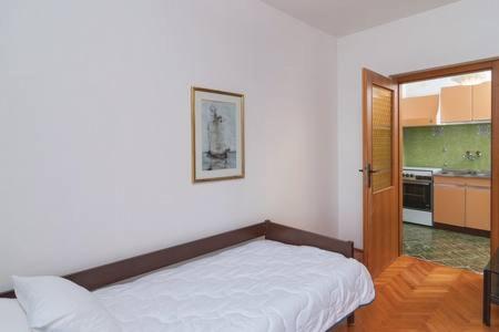 a bedroom with a bed and a kitchen at Beach Apartment Viktor 2 in Postira