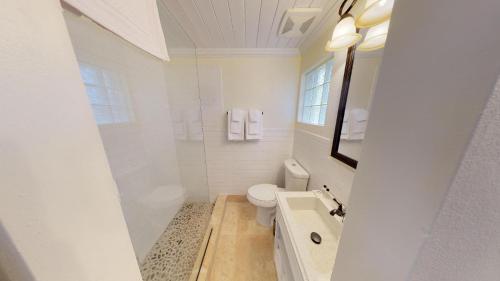 Company House Hotel في كريستيانستيد: حمام ابيض مع مرحاض ومغسلة