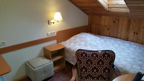 um pequeno quarto com uma cama e uma cadeira em Home B&B em Kaunas