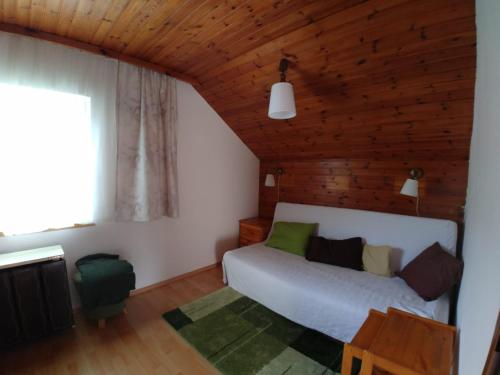 sypialnia z łóżkiem i drewnianym sufitem w obiekcie Apartment Fam. Zappe w mieście Steinhaus am Semmering