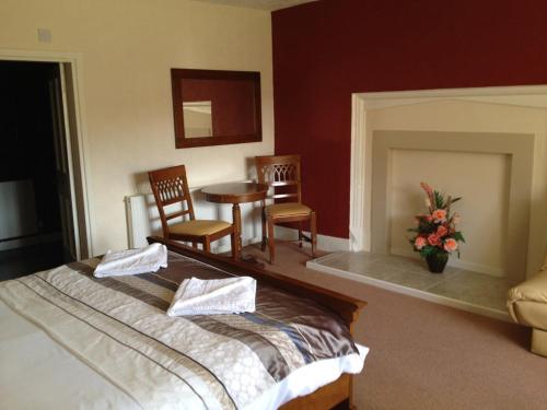 a bedroom with a bed and two chairs and a table at Clennell Hall Country House - Near Rothbury - Northumberland in Alwinton