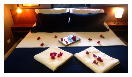 a bed with roses and a cake on it at Casa D'Aurora in Campos do Jordão