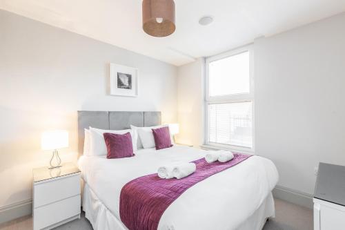 a bedroom with a large white bed with towels on it at Roomspace Serviced Apartments - The Quadrant in Richmond upon Thames