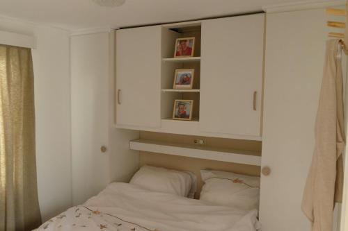 1 dormitorio con armarios blancos y 1 cama con almohadas en Het ScheldeChalet, en Baarland