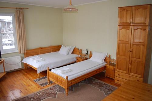 a bedroom with two beds and a cabinet at Borova House in Tryavna